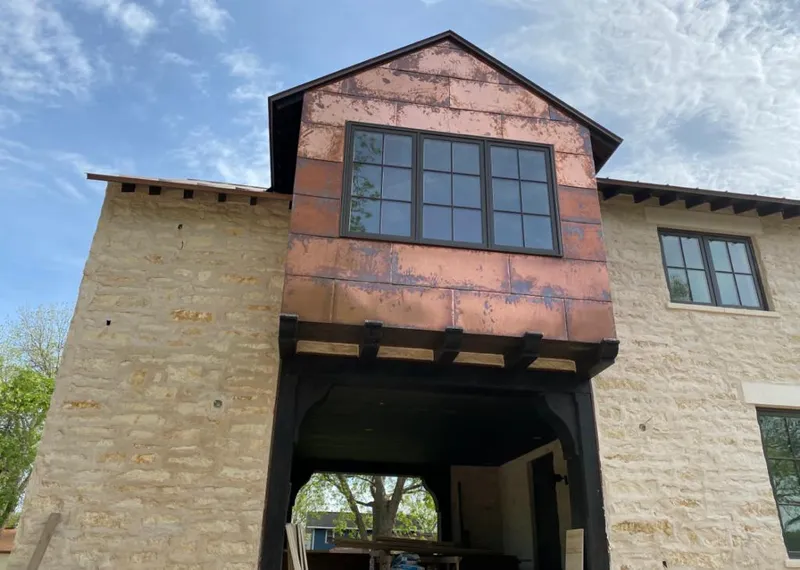 Copper metal panel facade on a stone building for Roof Repair in Chanute